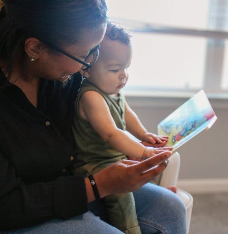 Woman reading book to child