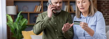 couple concerned about phone call with credit card in hand