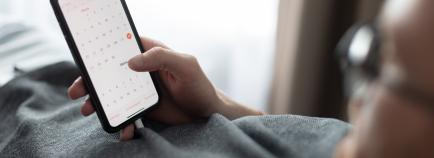 man on phone looking at calendar
