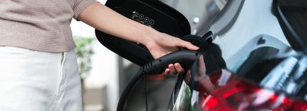 person charging electric vehicle