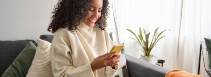 woman on at home on couch with her phone